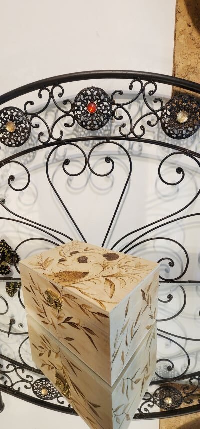 Sur les cotés du coffret en bois avec un dessin de panda, des motifs de branches pyrogravées sur