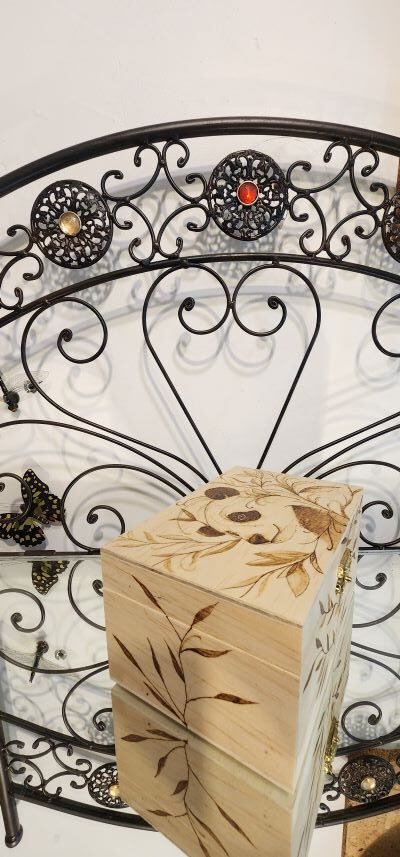 Motif de branches pyrogravées sur les côtés du coffret en bois au motif principal panda. Pyroart.