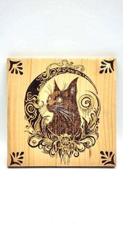 Pyrogravure sur bois représentant un chat entouré d’un croissant de lune et de motifs végétaux, création artisanale gravée à la main.