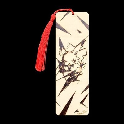 Marque-page Pikachu en bois pyrogravé avec pompon rouge sur fond noir